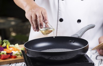 Chef pouring vegetable oil to the pan / Stir fried vegetable concept